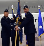 Maj. Gen. Randall A. Ogden, 4th Air Force commander, presents the wing guidon to Col. Terry W. McClain, 433rd Airlift Wing commander, at the 433rd AW change of command ceremony March 3 at Joint Base San Antonio-Lackland.