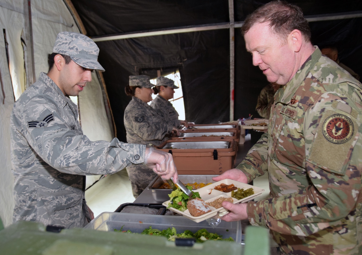 Senior Airman Jacob Livar (left), 433rd Force Support Squadron fitness specialist, serves a meal to Lt. Gen. Richard Scobee (right) , commander of the Air Force Reserve Command at Joint Base San Antonio-Lackland March 2. Scobee visited several organizations in the 433rd Airlift Wing.