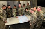 U.S. Army Col. Martine Kidd, U.S. Central Command's (USCENTCOM) chief of plans, strategy and policy, sixth from left, U.S. Air Force Col. Arno Bischoff, U.S. Air Forces Central Command’s director of installations, fourth from left, and leaders from USCENTCOM and supporting combatant commands review a logistics map during USCENTCOM's inaugural Joint Strategic Support Board (JSSB) wargame, Mar 1, 2019. The JSSB is a scenario-driven exercise designed to anticipate and address strategic support issues that provide engineering proficiency and logistical support to military operations ahead of the commander’s decision cycle. (U.S. Central Command Public Affairs photo by Tom Gagnier)