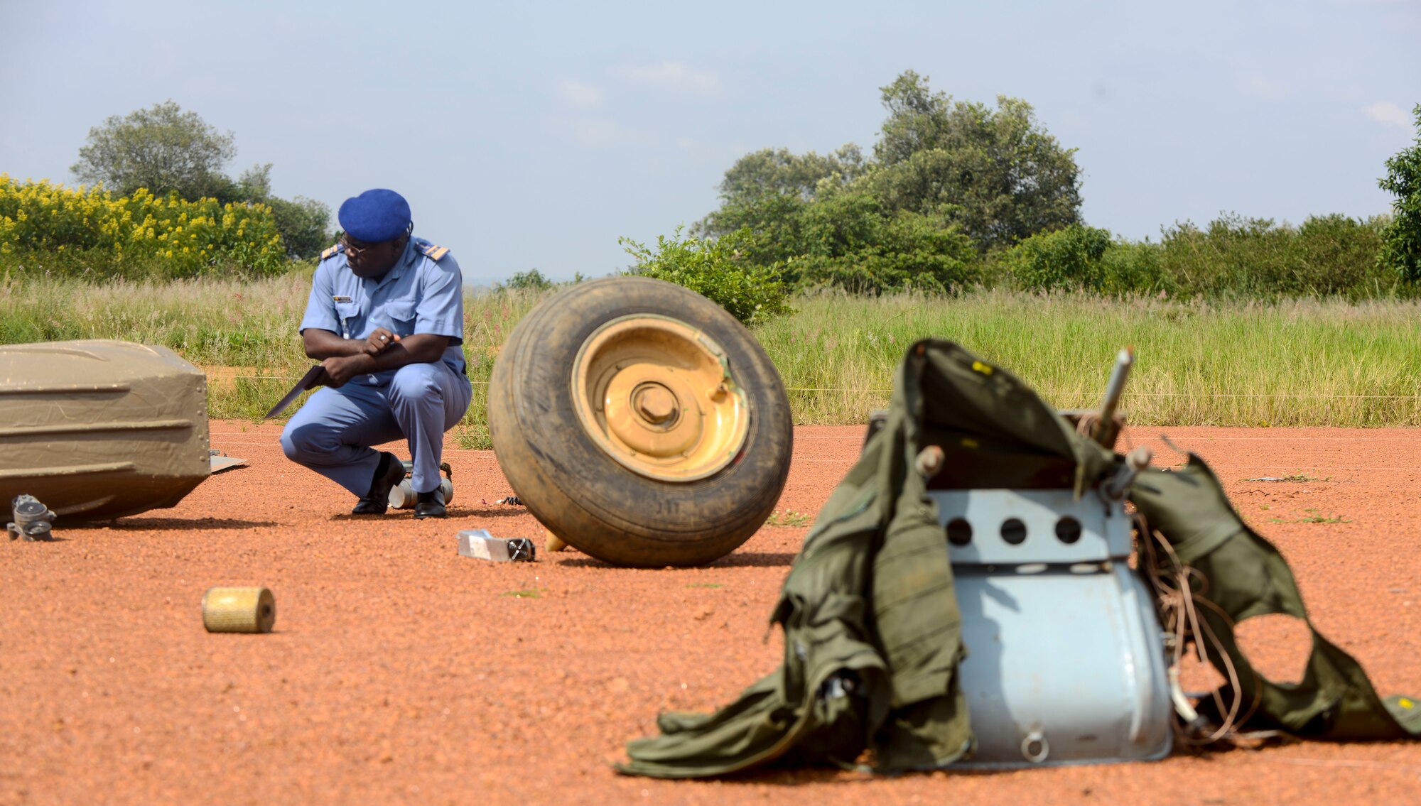 Cameroon Air Force Maj. Daniel Ohandja investigates an aircraft part during the African Partnership Flight Rwanda field familiarization exercise at the Rwanda Military Academy in Gako, Rwanda, March 7, 2019. Throughout the weeklong African Partnership Flight, participants discussed various aspects of safety, with each country discussing how they conduct their programs, culminating with teams investigating a simulated aircraft crash in the field familiarization exercise. (U.S. Air Force photo by Tech. Sgt. Timothy Moore)