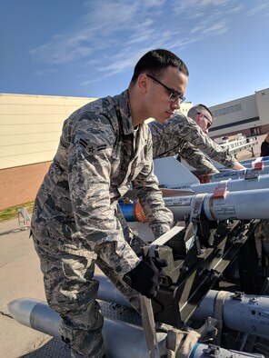 A1C Dylan Dodd secures bombs to a bomb rack