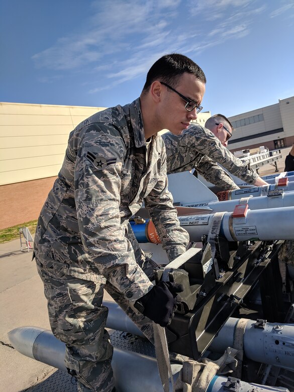 A1C Dylan Dodd secures bombs to a bomb rack