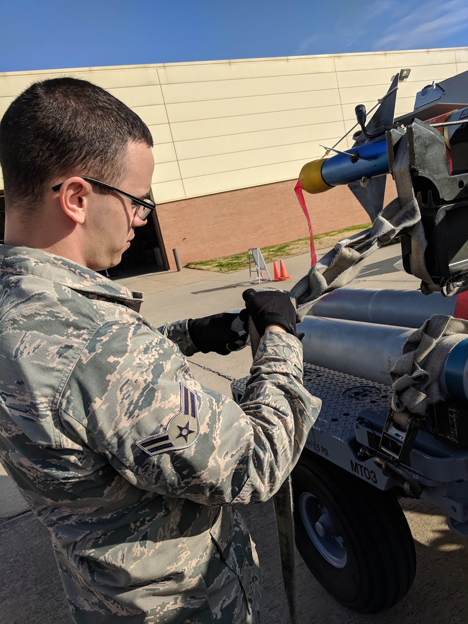 A1C Dylan Dodd secures bombs to a bomb rack