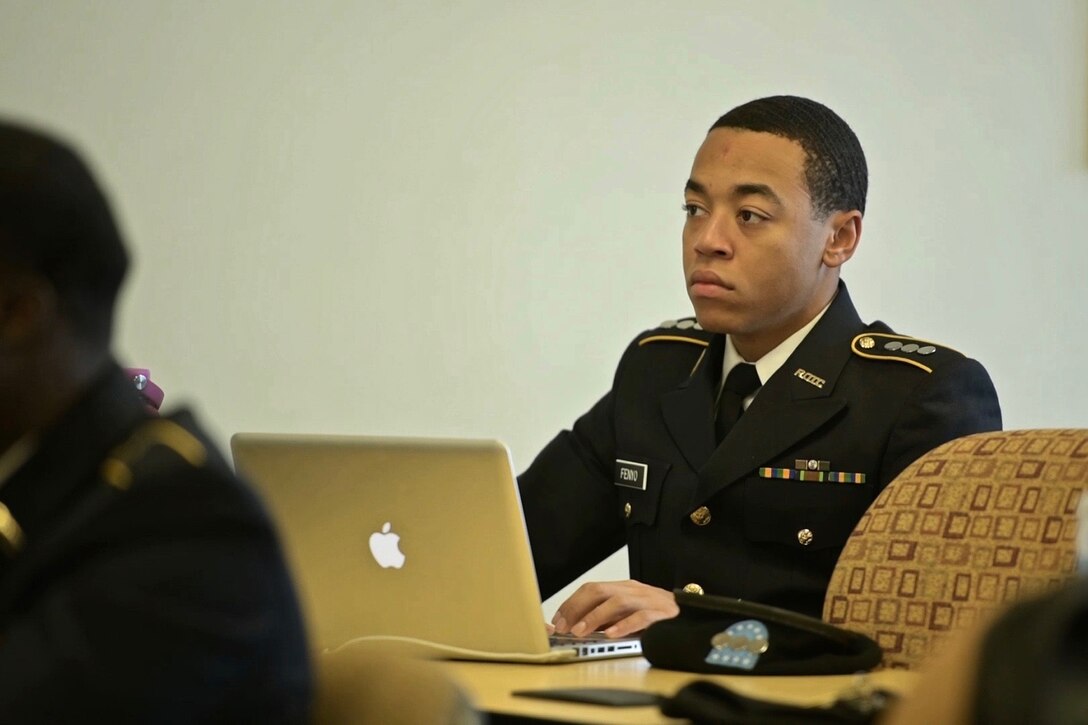 A man works at a laptop computer.