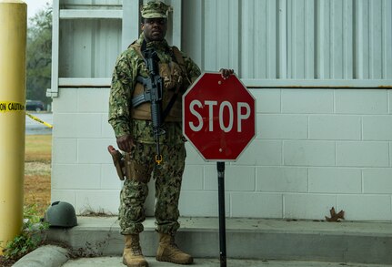 Gunners Mate Petty Officer 2nd Class Robert Dostaly, Coastal Riverine Squadron 10 Bravo 2nd Platoon, holds a stop sign during a deployment exercise March 5, 2019, at Joint Base Charleston, S.C. -- Naval Weapons Station.