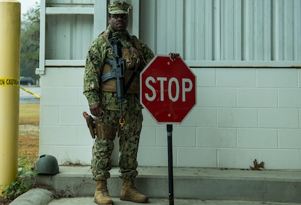 Gunners Mate Petty Officer 2nd Class Robert Dostaly, Coastal Riverine Squadron 10 Bravo 2nd Platoon, holds a stop sign during a deployment exercise March 5, 2019, at Joint Base Charleston, S.C. -- Naval Weapons Station.