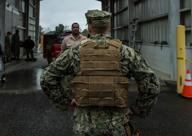 Master-at-Arms Petty Officer 3rd Class Adam Bolas, Coastal Riverine Squadron 10 Bravo 2nd Platoon, stands watch over a simulated foreign national during a deployment exercise March 5, 2019, at Joint Base Charleston, S.C. -- Naval Weapons Station.