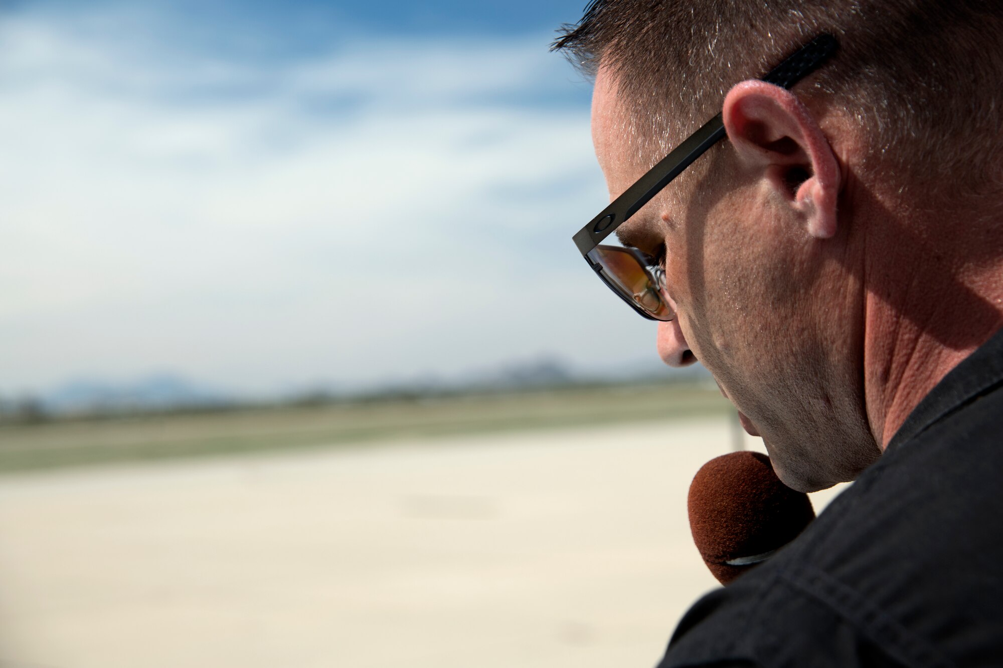 U.S. Air Force Master Sgt. Chris Schneider, F-16 Viper Demonstration Team superintendent, reads a narration script at Davis-Monthan Air Force Base, Ariz., March 1, 2019.