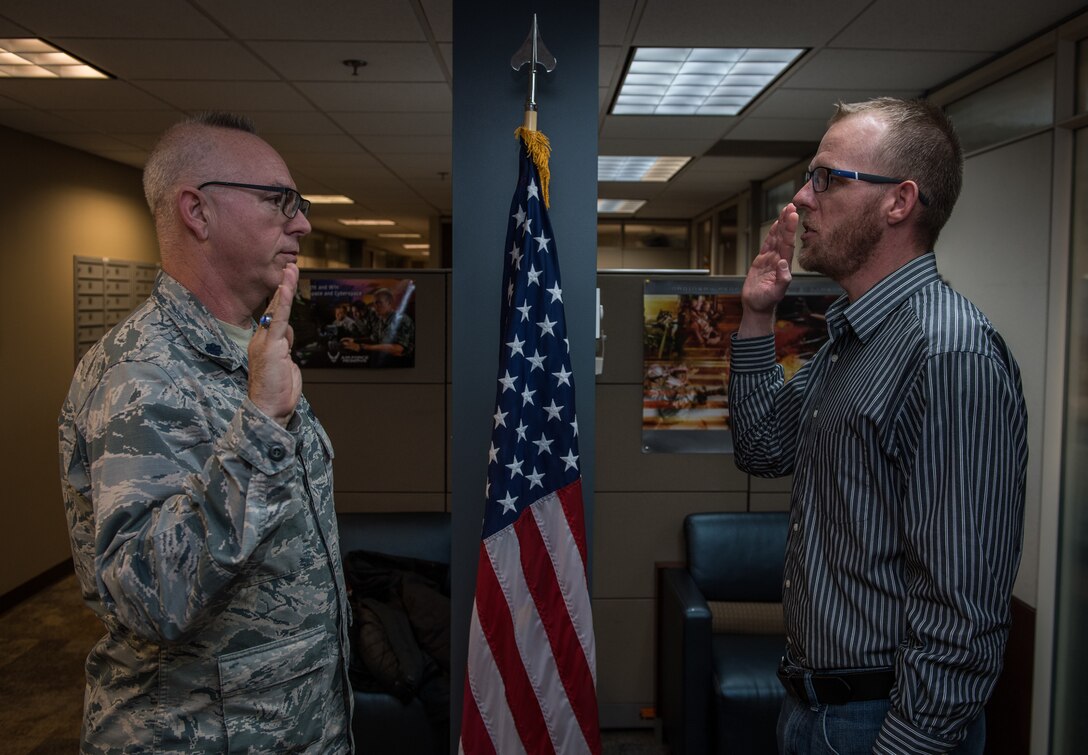 Tech. Sgt. Robert Wilmes, a medical logistics technician in the 932nd Medical Squadron, recites the oath of enlistment given to him on Mar. 8, 2019 by Lt. Col. Stan Paregien, 932nd Airlift Wing Public Affairs Officer, during a reenlistment ceremony at the 932nd AW Headquarters building, Scott Air Force Base, Illinois. Wilmes recently returned from a deployment and compared the experience to when he deployed with the U.S. Army before joining the Air Force. “It was different seeing more the behind the scenes while deployed versus being on the frontline,” said Wilmes.  (U.S. Air Force photo by Christopher Parr)