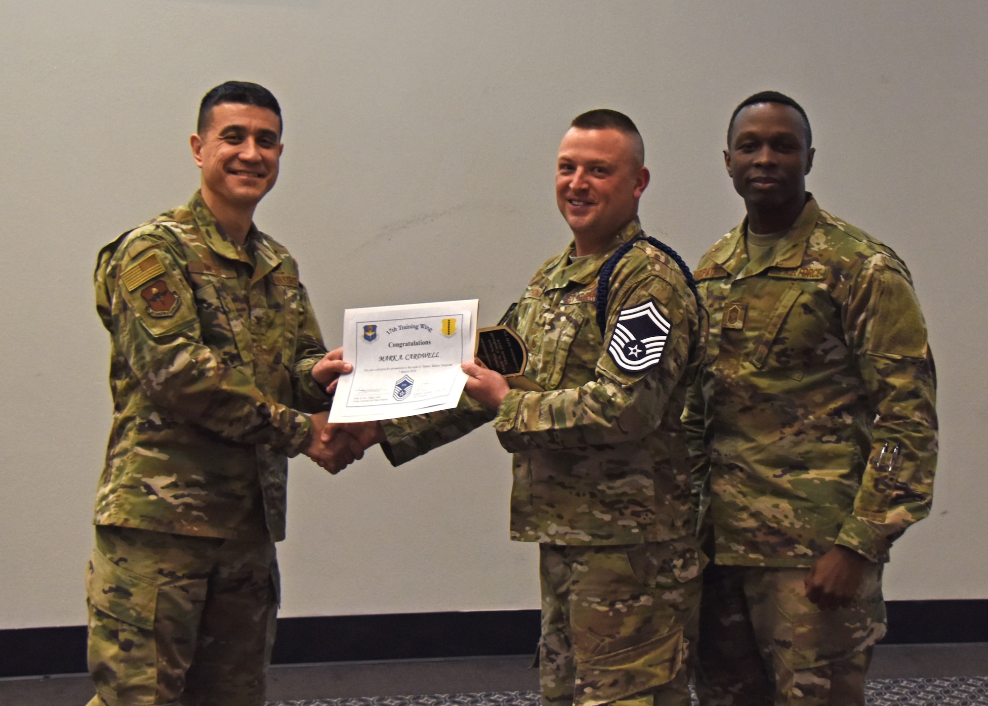 U.S. Air Force Col. Ricky Mills, 17th Training Wing commander, presents Master Sgt. Mark Cardwell, 17th Training Support Squadron/Training Support Military Training Leader flight chief, a certificate of promotion to the rank of senior master sergeant during the senior master sergeant release ceremony at the Event Center on Goodfellow Air Force Base, Texas, March 7, 2019. Members from team Goodfellow, friends and families came out to celebrate the three new senior master sergeants. (U.S. Air Force photo by Airman 1st Class Zachary Chapman/Released)