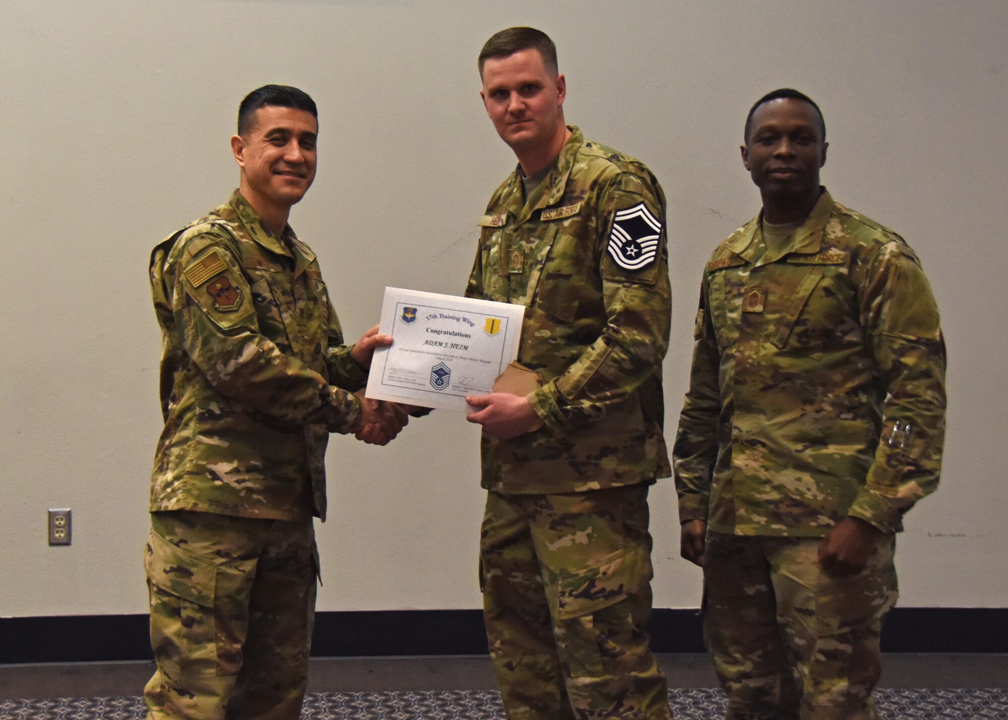 U.S. Air Force Col. Ricky Mills, 17th Training Wing commander, presents Master Sgt. Adam Heim, 17th Contracting Squadron superintendent, a certificate of promotion to the rank of senior master sergeant during the senior master sergeant release ceremony at the Event Center on Goodfellow Air Force Base, Texas, March 7, 2019. Within the Air Force, only 10 percent of enlisted members will make it to the rank of senior master sergeant. (U.S. Air Force photo by Airman 1st Class Zachary Chapman/Released)