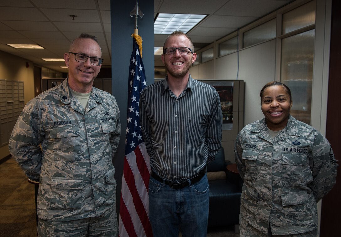 Air Force Reserve citizen Airman, Tech. Sgt. Robert Wilmes, center, poses with Master. Sgt. Tanielle Phillips, 932nd Airlift Wing career assistance advisor, right, and Lt. Col.Stan Paregien, 932nd AW Public Affairs Officer, following Wilmes’s  reenlistment, Mar. 8, 2019, Scott Air Force Base, Illinois. Wilmes looks forward to reaching 20 years and might even do a few extra. (U.S. Air Force photo by Christopher Parr)