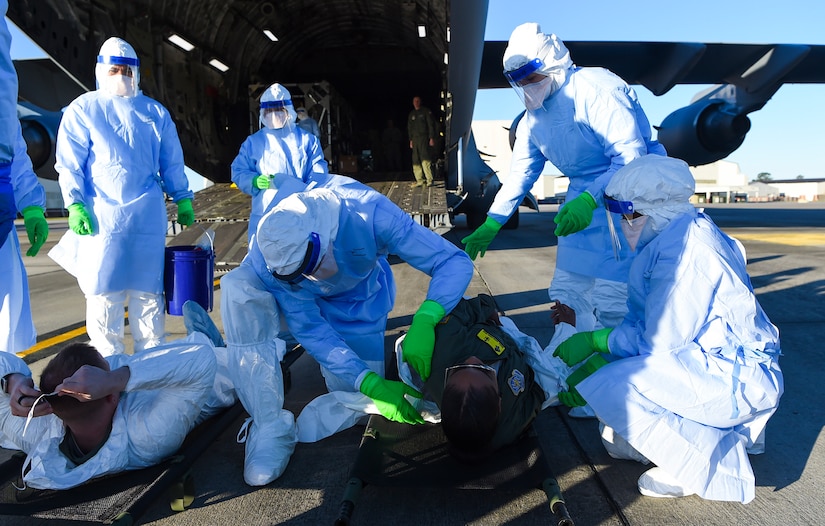 Airmen taking part in transportation isolation system training March 6, 2019, attend to simulated patients during an exercise designed to enhance how the Air Force transports patients and their medical professionals at Joint Base Charleston, S.C. Engineered and implemented after the Ebola virus outbreak in 2014, the TIS is an enclosure the Department of Defense can use to safely transport patients with highly contagious diseases.