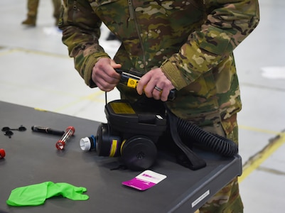 An Airman prepares and inspects his gear before donning personal protective equipment March 5, 2019 during transportation isolation system training at Joint Base Charleston, S.C. Engineered and implemented after the Ebola virus outbreak in 2014, the TIS is an enclosure the Department of Defense can use to safely transport patients with highly contagious diseases.