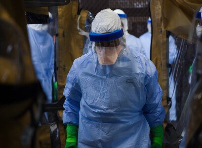 An Airman carries a training dummy into a transportation isolation system March 5, 2019, during an exercise at Joint Base Charleston, S.C. Engineered and implemented after the Ebola virus outbreak in 2014, the TIS is an enclosure the Department of Defense can use to safely transport patients with highly contagious diseases.