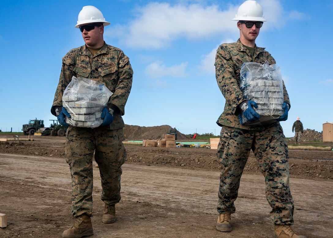 Lance Cpl. Mathew Adams, left, and Lance Cpl. Kadin Peckhanson, combat engineers with Marine Wing Support Squadron (MWSS) 373, Marine Wing Support Group (MWSG) 37, 3rd Marine Aircraft Wing (MAW), carry concrete blocks to the foundation site as part of the Catalina Island Airport in the Sky project at Catalina Island, Calif., Jan. 21. The Catalina Island Airport in the Sky project is a strategic training opportunity which allows a rare collaboration that benefits both the Marine Corps and the Catalina Island Conservancy. (U.S. Marine Corps photo by Lance Cpl. Juan Anaya)