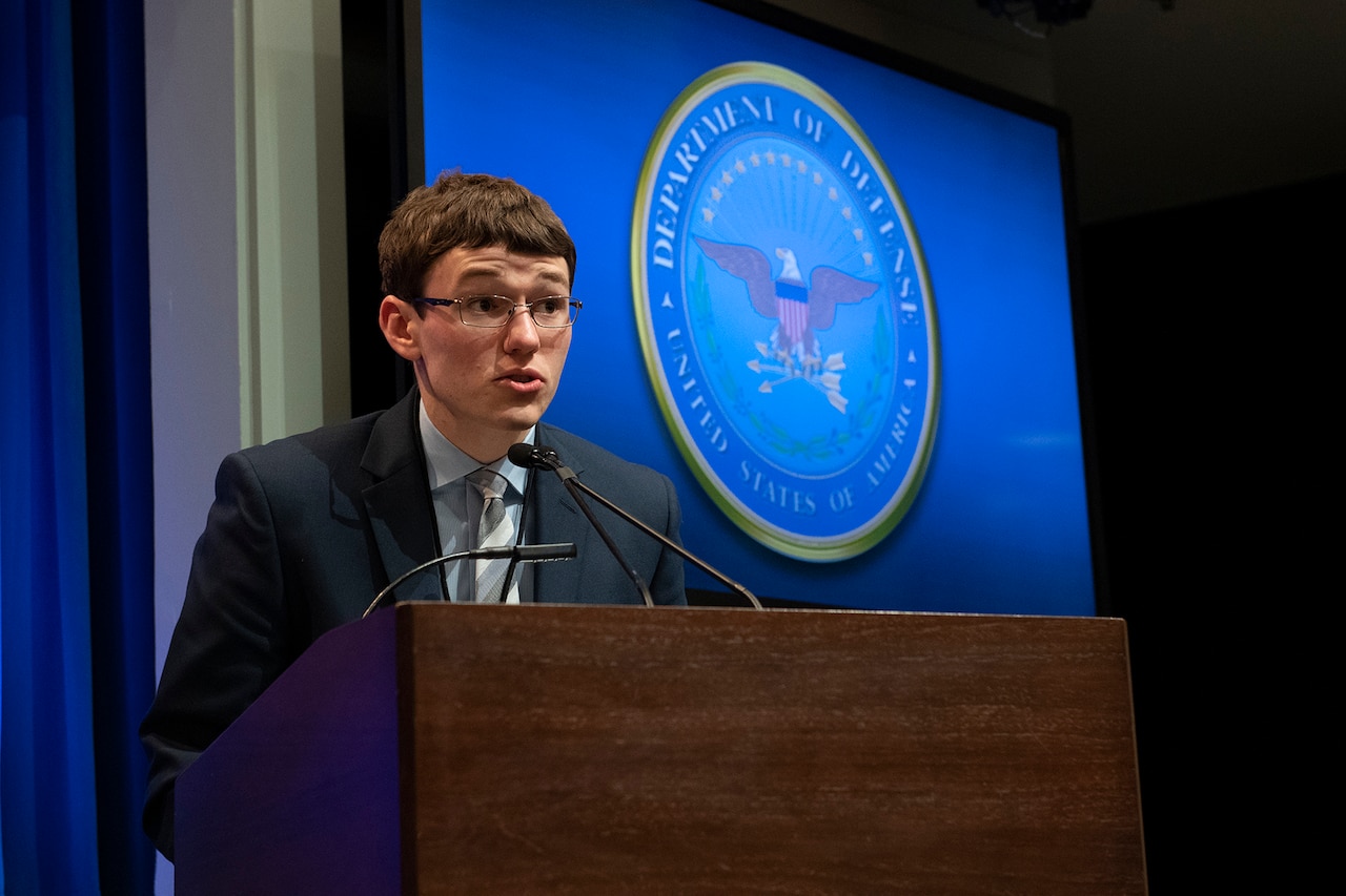 A young man speaks at lectern.