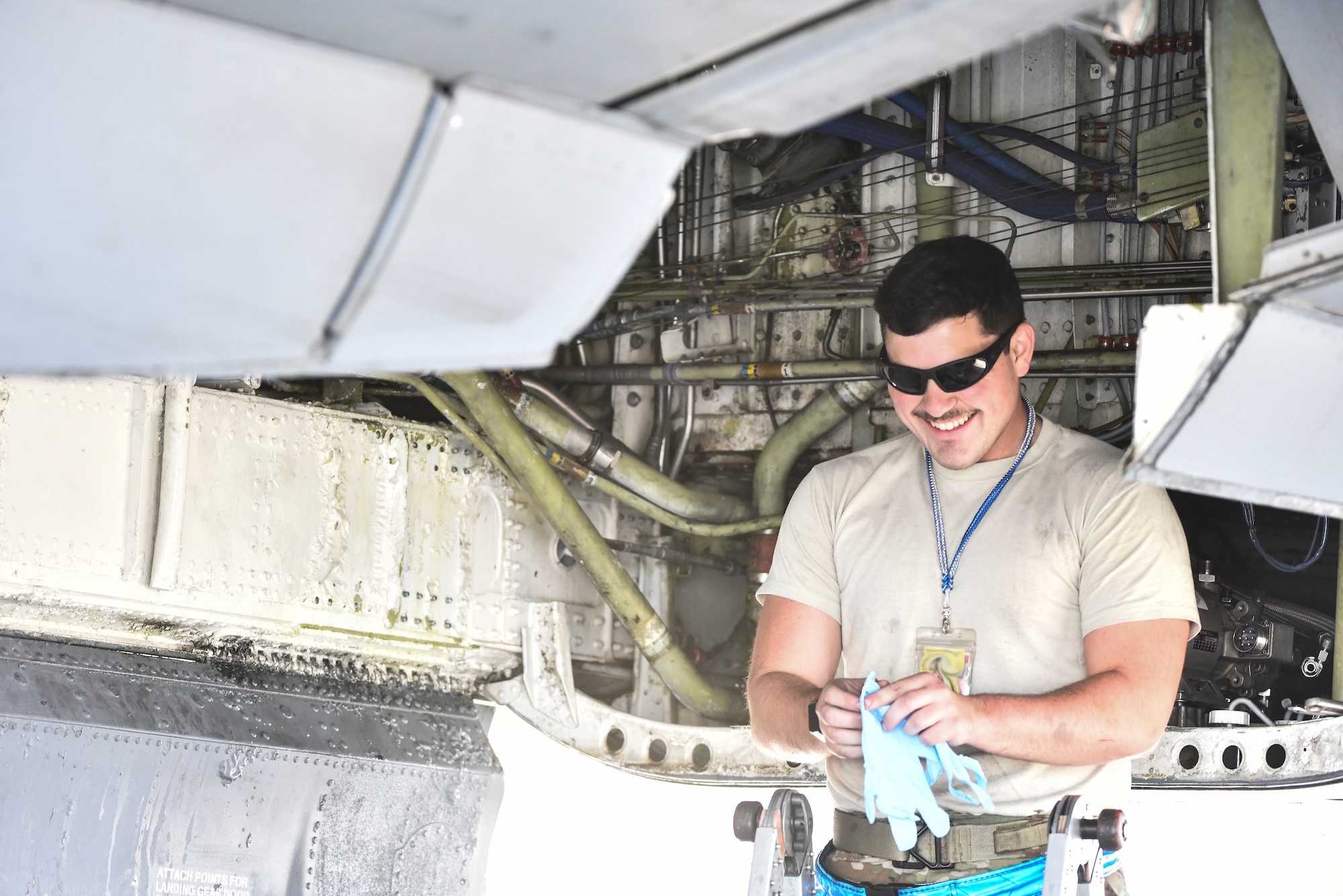 Senior Airman Brian Rizzolo, 380th Expeditionary Aircraft Maintenance Squadron hydraulic systems specialist, puts on gloves at Al Dhafra Air Base, United Arab Emirates, Mar. 5, 2019. Hydraulic systems specialists are responsible for maintaining fluid-, air- or gas-pressured devices on aircraft. (U.S. Air Force photo by Senior Airman Mya M. Crosby)
