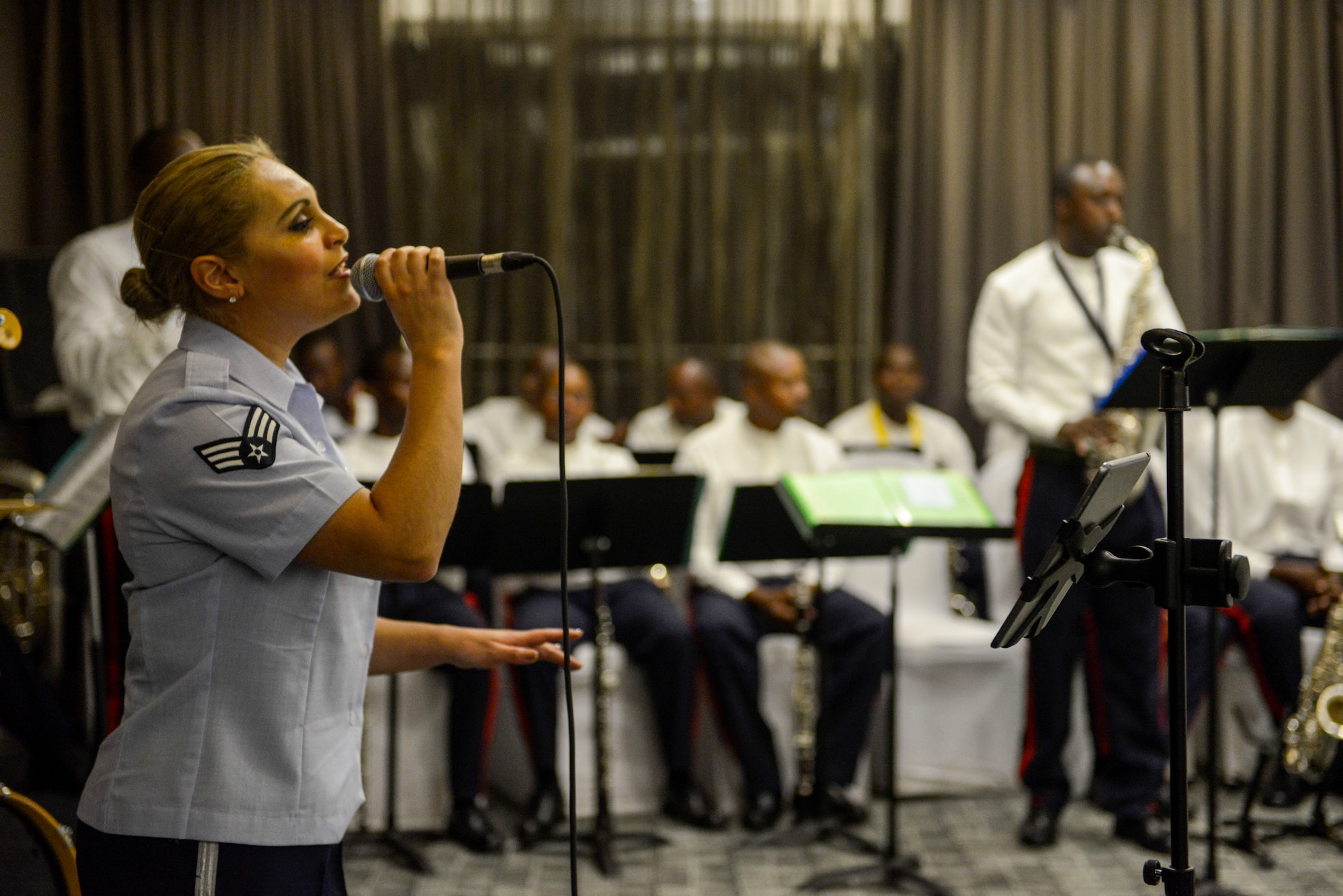 U.S. Air Force Senior Airman Linda Casul, U.S. Air Forces in Europe Band vocalist, sings a song accompanied by musicians of the Rwanda Defence Force Band during an African Partnership Flight Rwanda cultural dinner in Kigali, Rwanda, March 7, 2019. The bands used music to enhance the people-to-people relationship between the United States, Rwanda, and the other participating countries in the APF Rwanda. (U.S. Air Force photo by Tech. Sgt. Timothy Moore)