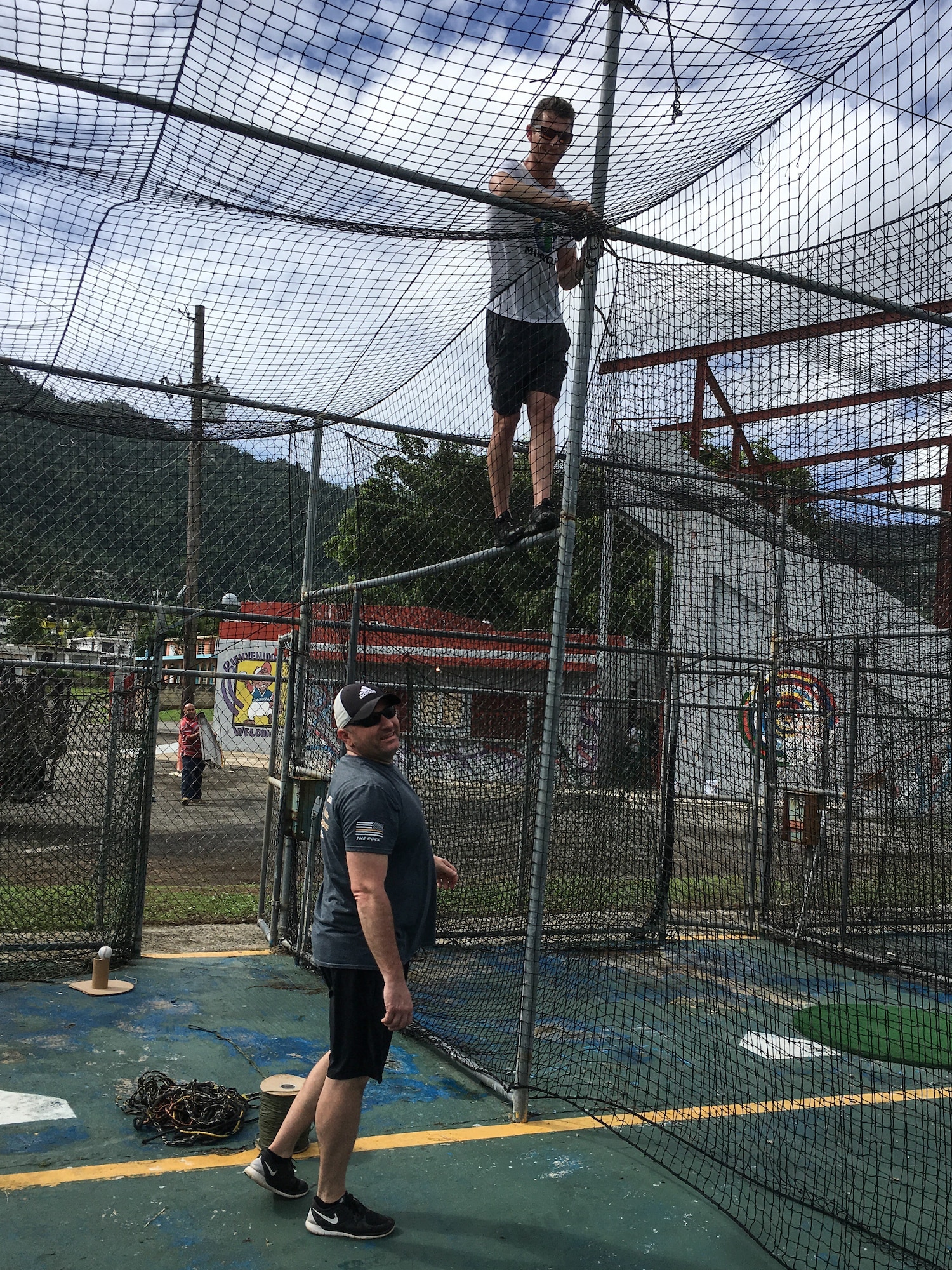 Air Force Chief Master Sgt. Greg Souders, left, the superintendent of the 193rd Special Operations Logistics Readiness Squadron, Pennsylvania Air National Guard, and fellow Baseball Miracles member Michael McCarthy repair a batting cage during a Baseball Miracles event.