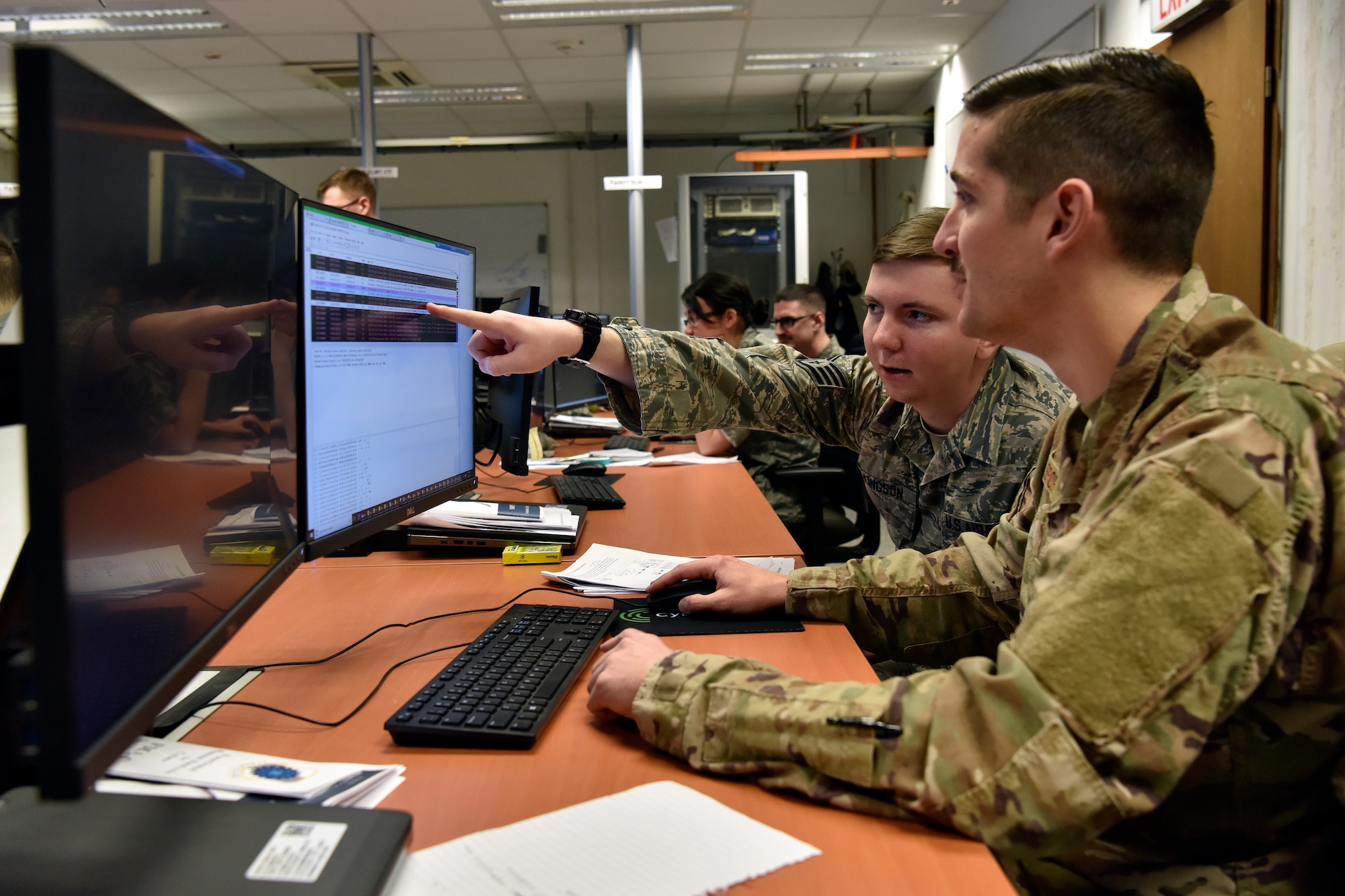 Staff Sgt. Tyler Ellingson (left), 100th Communications Squadron mission defense team supervisor, and Staff Sgt. Stephen Spor, 31st CS noncommissioned officer in charge, mission defense team, analyze information systems for potential malicious activity as part of a training scenario during exercise TACET VENARI