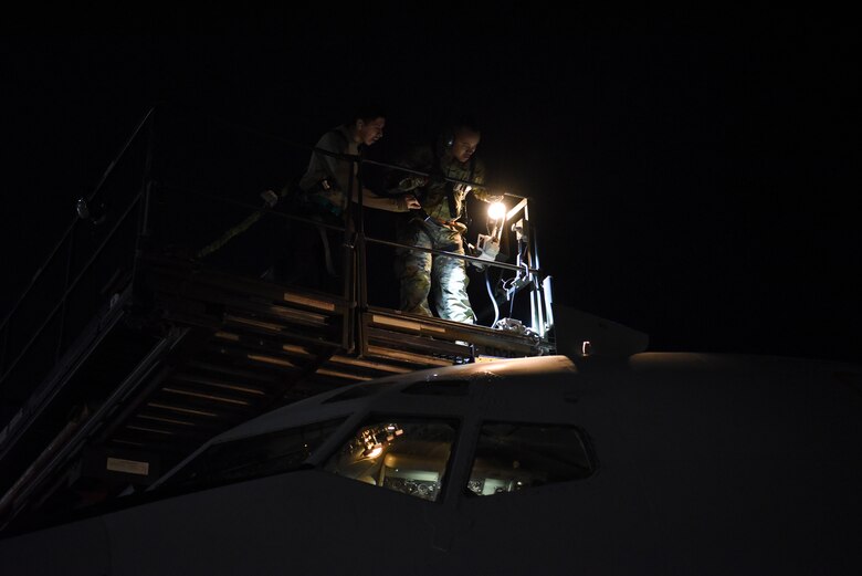 380th Expeditionary Aircraft Maintenance Squadron crew chief members inspect the top of an E-3 Sentry after landing at Al Dhafra Air Base, United Arab Emirates, Mar. 7, 2019.