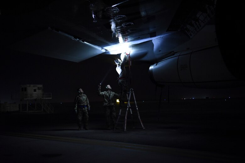 380th Expeditionary Aircraft Maintenance Squadron crew chief members inspect underneath the wing of an E-3 Sentry after landing at Al Dhafra Air Base, United Arab Emirates, Mar. 7, 2019.