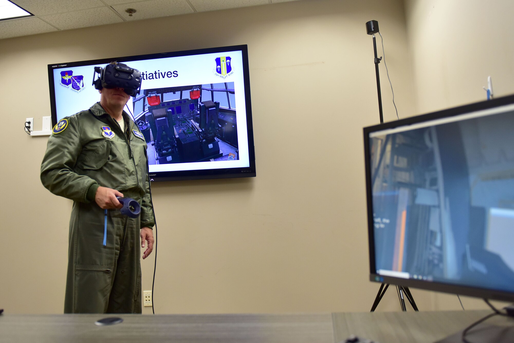 A man wearing the Air Force flight suit uses virtual reality training devices.