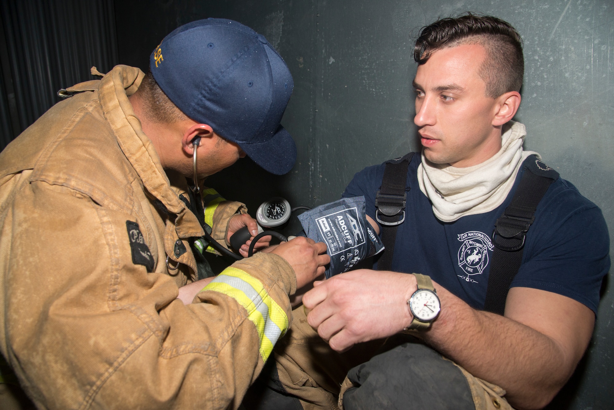 A firefighter measures the vital signs of Senior Airman Kyle Coleman, right, both assigned to the 153rd Airlift Wing in Cheyenne, Wyo., during a joint, firefighting training exercise at MacDill Air Force Base, Fla., March 5, 2019.