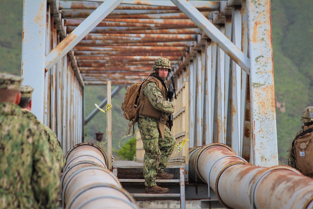 A student walks up steps in between two metal barriers.