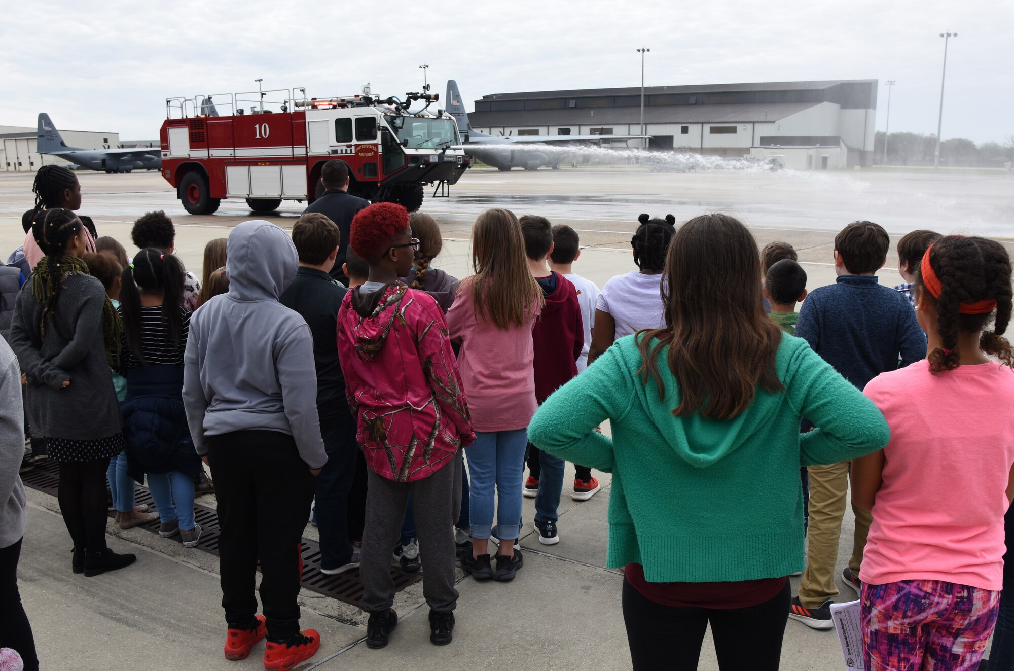 Members of the Keesler Fire Department spray water from a fire truck for school-aged children during Biloxi School District Career Exploration Day on Keesler Air Force Base, Mississippi, March 7, 2019. The children also toured the 334th Training Squadron air traffic control school, 335th TRS weather facility and received a demonstration from the 81st Security Forces Squadron military working dogs. (U.S. Air Force photo by Kemberly Groue)