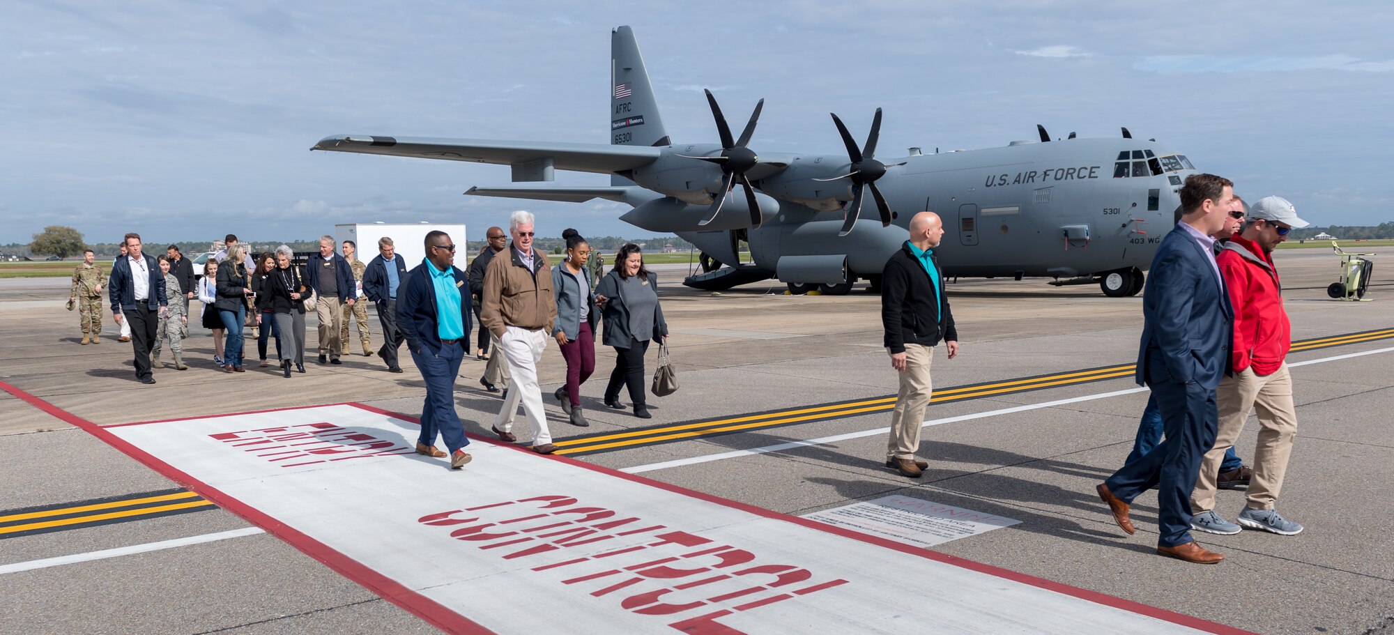 Keesler honorary commanders exit the flight line following a static display tour of a WC-130J Hercules during the 403rd Wing Honorary Commanders Tour at Keesler Air Force Base, Mississippi, March 08, 2019. The tour was intended to familiarize honorary commanders with the 403rd Wing and the Air Force Reserve mission and capabilities. The event also included an incentive flight on a WC-130J Hercules. (U.S. Air Force Photo by Andre' Askew)