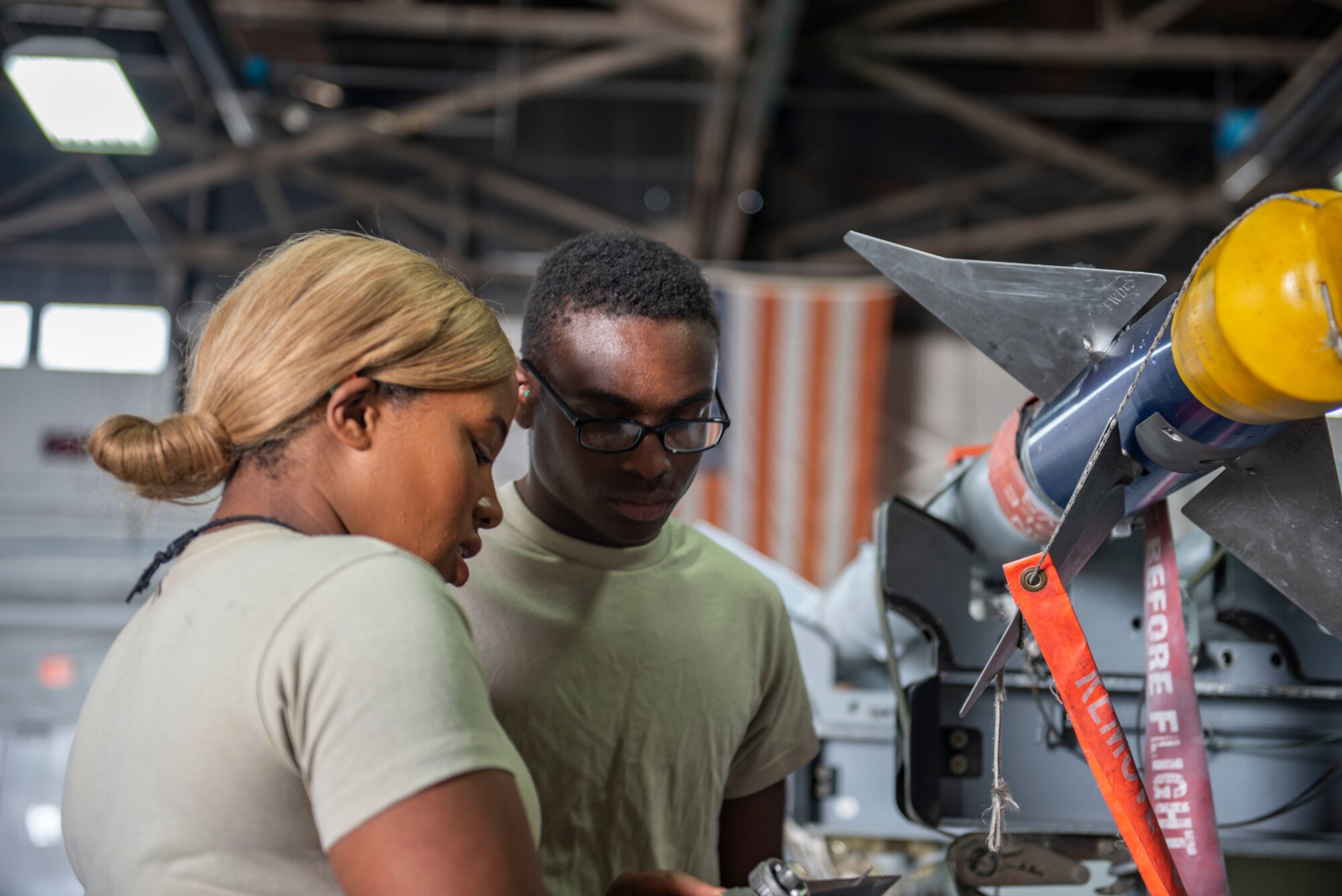 U.S. Air Force Senior Airman Genesa Williams, 20th Maintenance Group Operations weapons standardization load crew member team lead, trains a new Airman on how to attach a missile during Women’s History Month at Shaw Air Force Base, S.C., March 8, 2019.