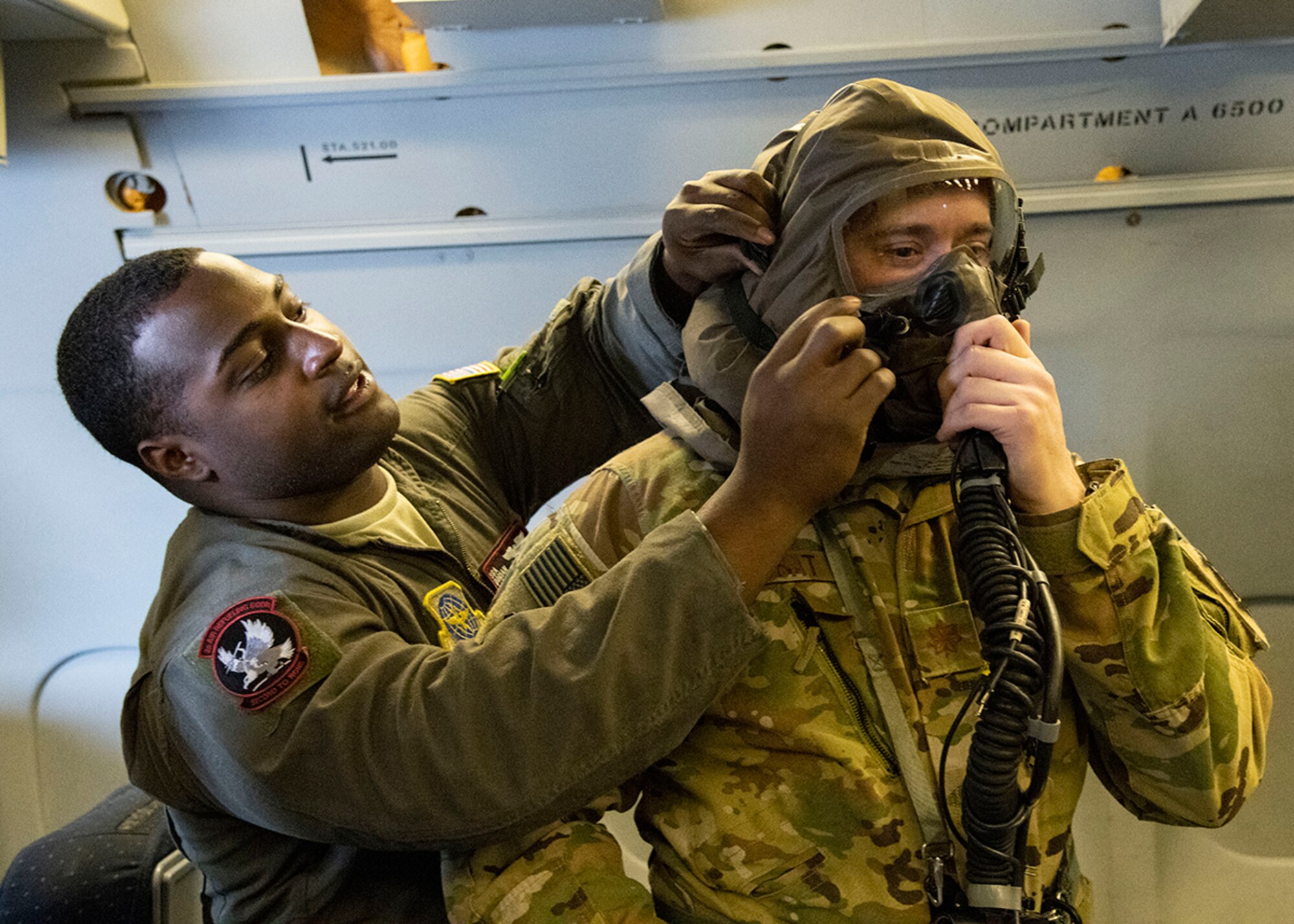 Senior Airman Dorian Cozart, boom operator with the 2nd Air Refueling Squadron, assists Major Brett Kubat, KC-10 Extender pilot with the 2nd ARS, in donning his Aircrew/Eye Respiratory Protection (AERP) gear prior to takeoff March 7, 2019, during Exercise Jersey Devil 19 in Gulfport, Miss. Jersey Devil was aimed at preparing Airmen to respond to complex threats anywhere, anytime. (U.S. Air Force photo by Airman 1st Class Zoe M. Wockenfuss)