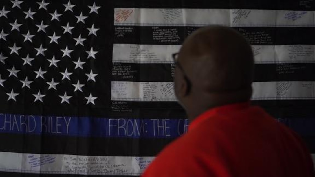 Richard Riley, civilian police officer with Security and Emergency Services Battalion, Marine Corps Base Camp Pendleton, admires his flag, in Chula Vista, California, March 10, 2019. Riley's fellow police officers gifted him an American flag with personal messages written on the flag. (U.S. Marine Corps photo by Cpl. Megan Roses)