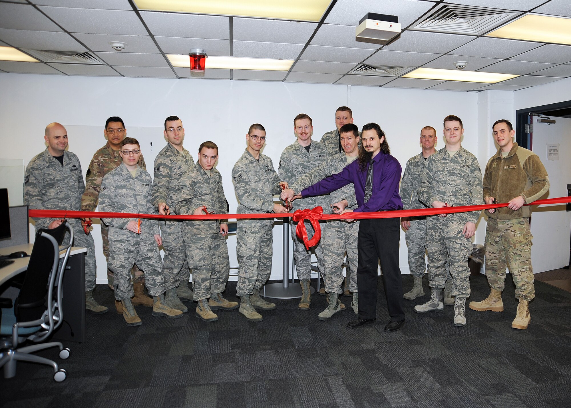 U.S. Air Force members with the Soaring Buffalo team cut a ceremonial ribbon at Offutt Air Force Base, Nebraska, Jan. 25, 2019. In June 2018, five members from the 20th Intelligence Squadron began building a network of like-minded Airmen to out-innovate U.S. adversaries; his network, known as Soaring Buffalo, consists of Airmen from multiple Air Force career fields, squadrons, wings, Numbered Air Forces and major commands working together to solve warfighter problems. (U.S. Air Force courtesy photo)