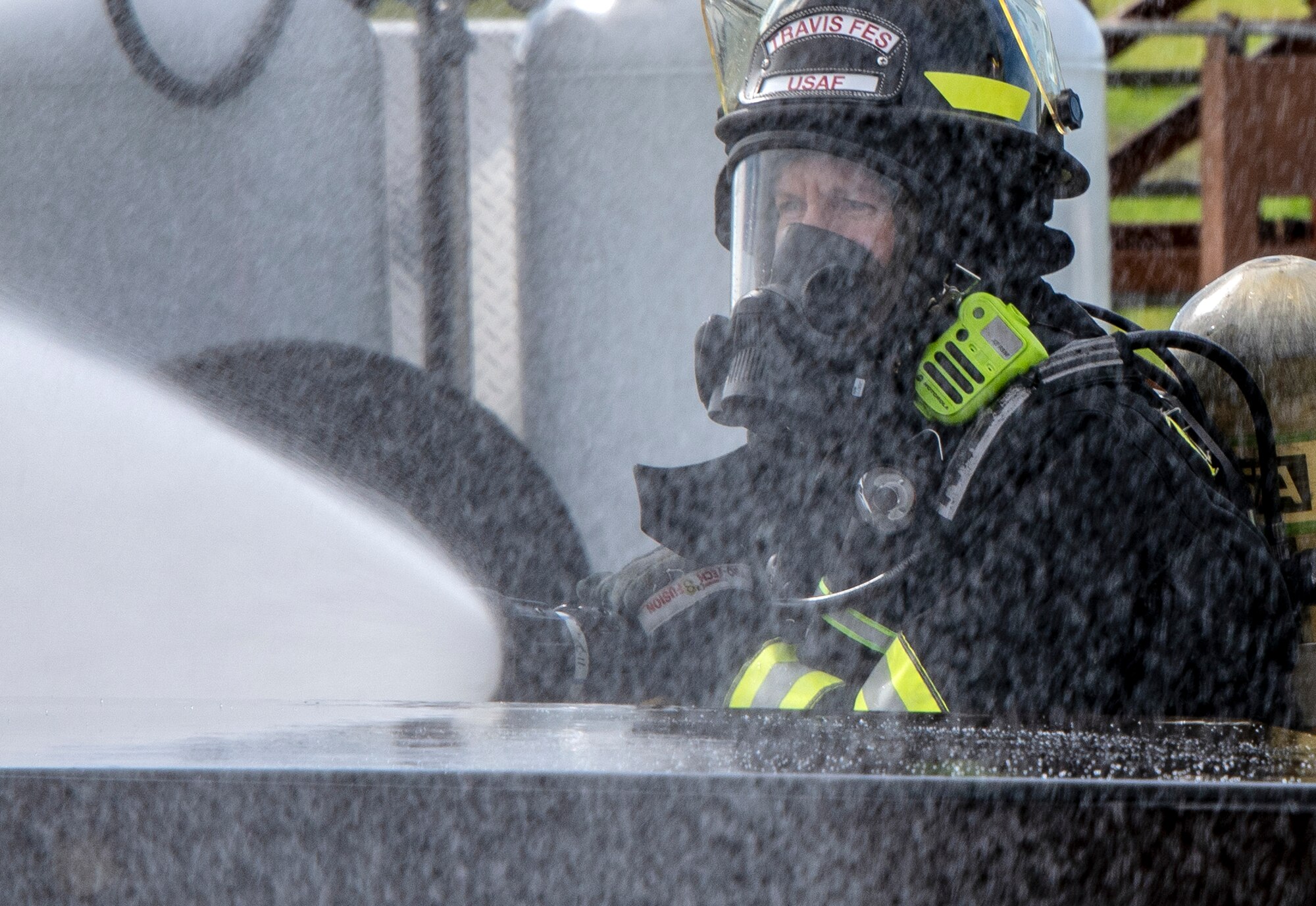 U.S. Air Force Airman 1st Class Autum Boomershine a firefighter for the 60th Civil Engineer Squadron, sprays water on a simulated crash site during a major accident response exercise, Feb. 28, 2019, Travis Air Force Base, California. The MARE was used to evaluate how different base agencies respond to emergency situations. (U.S. Air Force photo by Heide Couch)