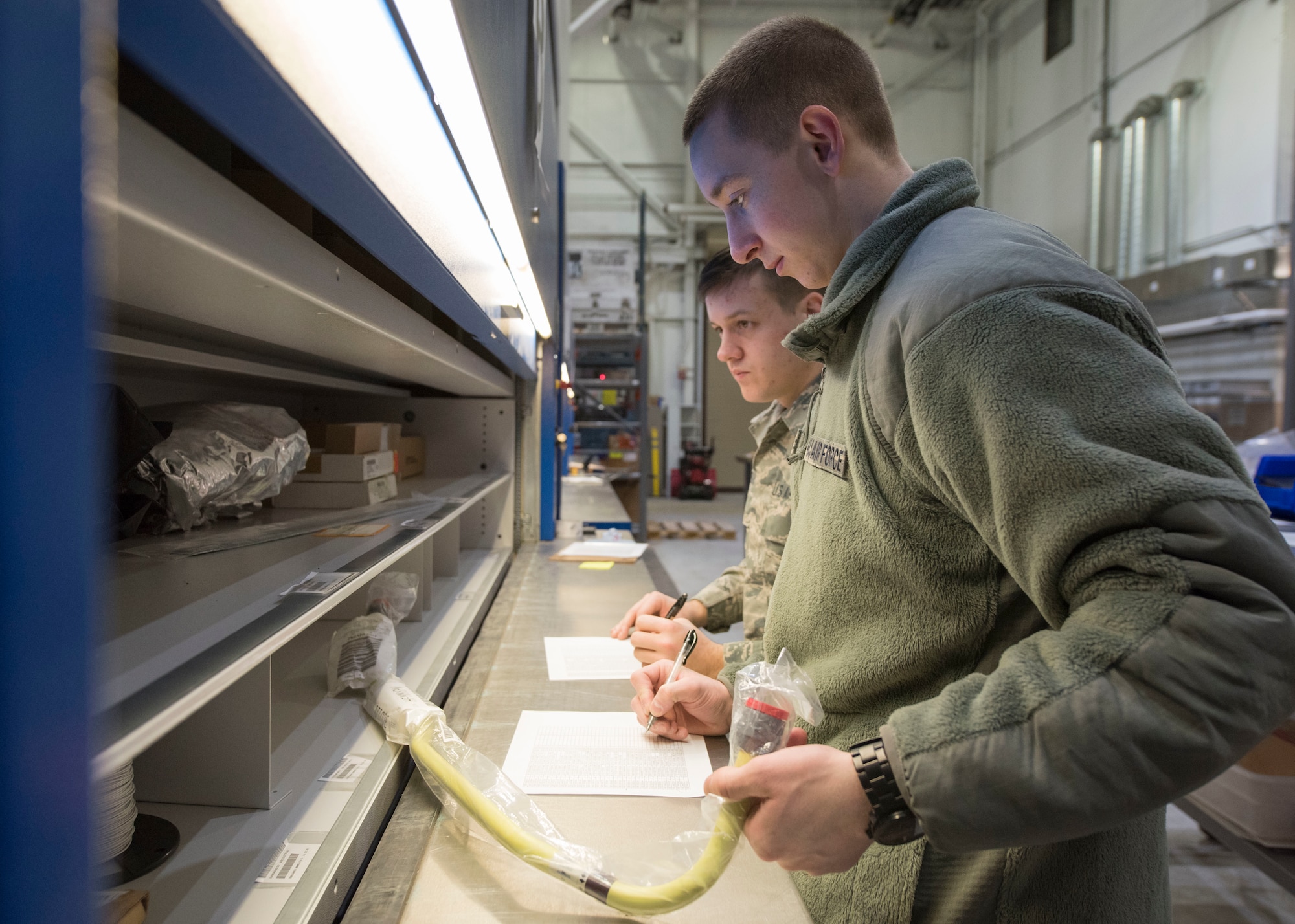 New Hampshire Air National Guardsmen Airman 1st Class Ryan Allen and Airman Timothy Gregoire, both from the 157th Logistics Readiness Squadron’s central storage, validate the specific location and stock numbers of parts, March 11, 2019, at Joint Base Elmendorf-Richardson, Alaska. While at JBER, the Guardsmen are training as well as helping with the transfer of all C-17 Globemaster III supply turnover from the 673d LRS to the Alaska Air National Guard’s 176th LRS.