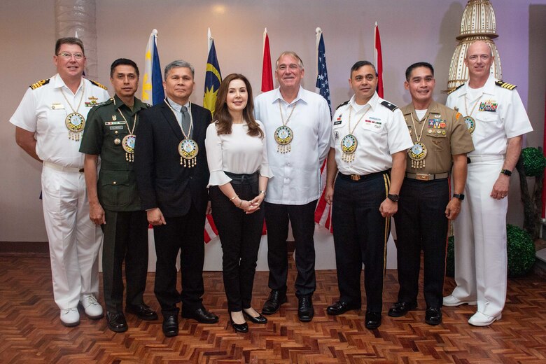 Tacloban City, Philippines – Military members and government officials from the United States, Australia and the Philippines involved in Pacific Partnership 2019 (PP19) pose for a photo during the PP19 Opening Ceremony. Pacific Partnership, now in its 14th iteration, is the largest annual multinational humanitarian assistance and disaster relief preparedness mission conducted in the Indo-Pacific. Each year the mission team works collectively with host and partner nations to enhance regional interoperability and disaster response capabilities, increase security and stability in the region, and foster new and enduring friendships in the Indo-Pacific.