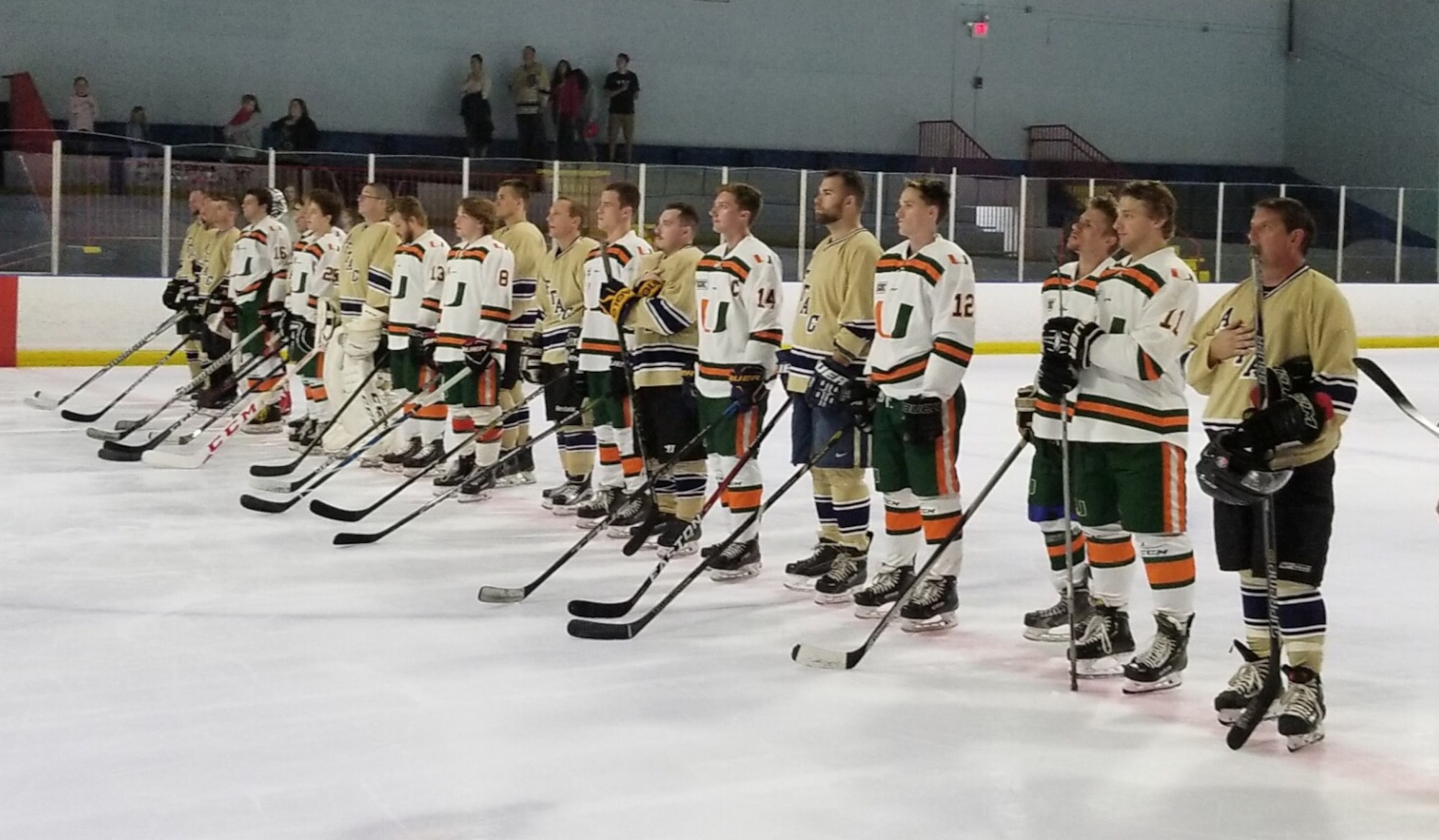 Members of the Miami Hurricanes hockey team stand in unity with the Air Force Technical Applications Center hockey club during the National Anthem Feb. 23, 2019 at an exhibition game at Pembroke Pines Ice Arena, Miami’s home rink.  AFTAC went on to defeat the 'Canes 12-8.  (Courtesy Photo)