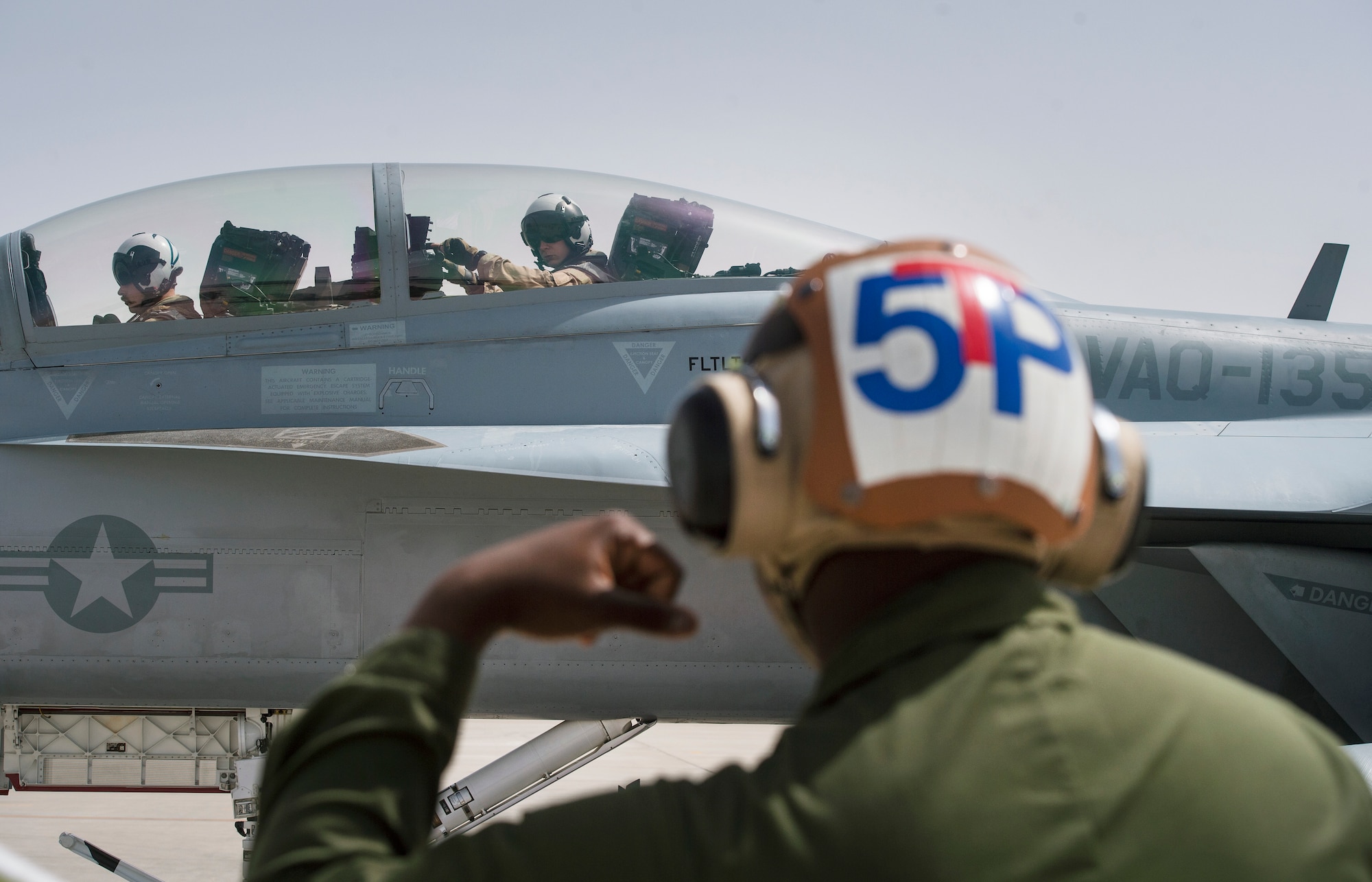 U.S. Navy EA-18G Growler pilots from the Electronic Attack Squadron 135 (VAQ-135) “Black Ravens,” conduct pre-flight inspections for an EA-18G Growler, with the help of a VAQ-135 aircraft maintainer March 4, 2019, at Al Udeid Air Base, Qatar. VAQ-135 is deployed to the U.S. 5th Fleet area of operations in support of naval operations to ensure maritime stability and security in the Central Region, connecting the Mediterranean and the Pacific through the western Indian Ocean and three strategic choke points. The squadron’s EA-18G Growlers employ an electronic attack capability in support of combat missions across the region. (U.S. Air Force photo by Tech. Sgt. Christopher Hubenthal)