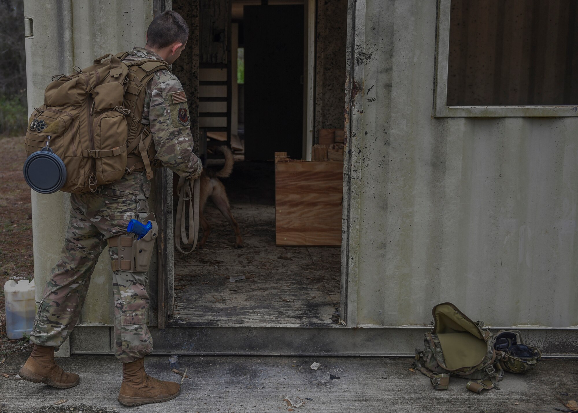 Security Forces Airman checkouts the inside of a bulding from the doorway