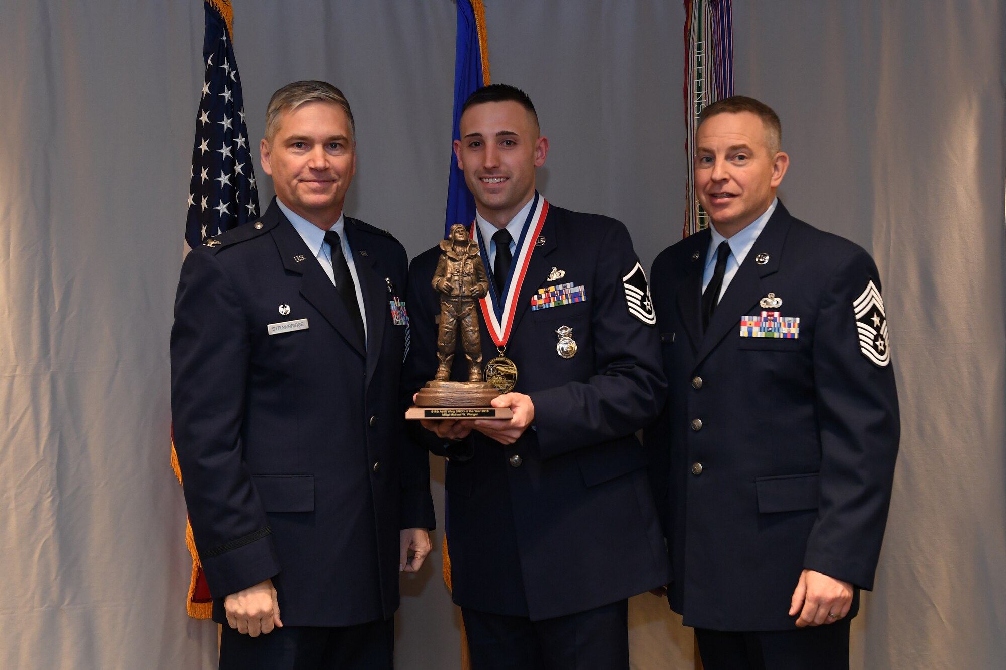 Master Sgt. Michael Wenger, flight chief with the 911th Security Forces Squadron, is awarded 911th Airlift Wing Senior Noncommissioned Officer of the Year by Col. Douglas N. Strawbridge, commander of the 911th AW, and Chief Master Sgt. Christopher D. Neitzel, command chief of the 911th AW, during the 911th AW Annual Award Ceremony at the Pittsburgh International Airport Air Reserve Station, Pennsylvania, March 2, 2019. The 2018 awards ceremony recognized Airmen who went above and beyond in their service for the year 2018. (U.S. Air Force photo by Senior Airman Grace Thomson)