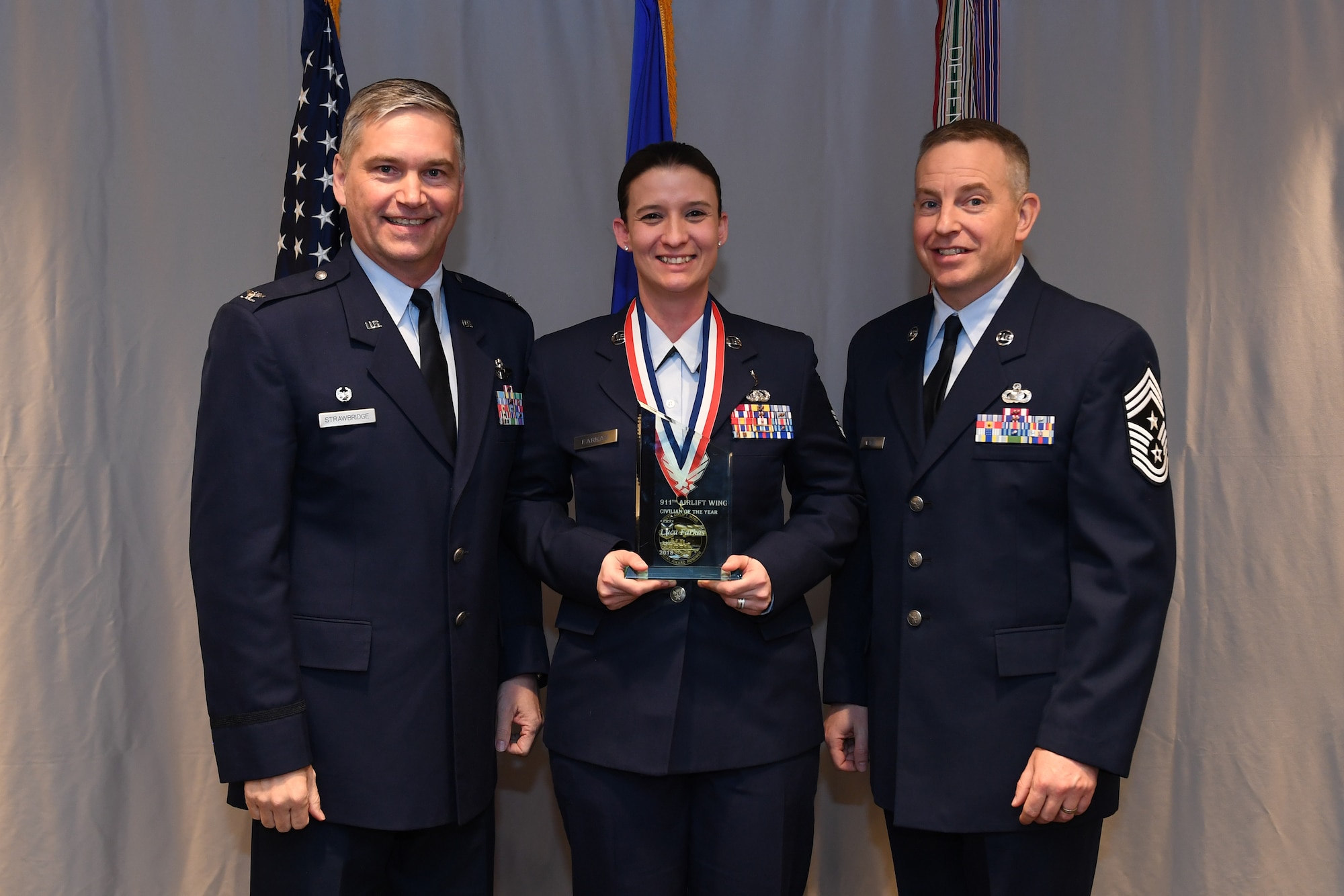 Master Sgt. Luca Farkas, medical technician with the 911th Aeromedical Staging Squadron is awarded 911th Airlift Wing Civilian of the Year (Category I) by Col. Douglas N. Strawbridge, commander of the 911th AW, and Chief Master Sgt. Christopher D. Neitzel, command chief of the 911th AW, during the 911th AW Annual Award Ceremony at the Pittsburgh International Airport Air Reserve Station, Pennsylvania, March 2, 2019. The 2018 awards ceremony recognized Airmen who went above and beyond in their service for the year 2018. (U.S. Air Force photo by Senior Airman Grace Thomson)