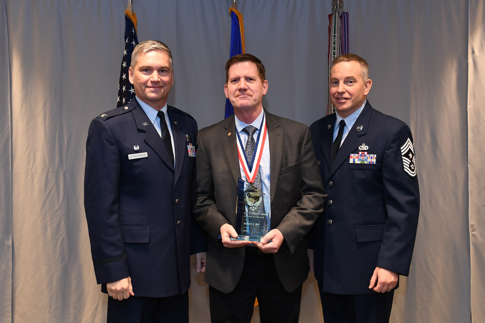 Robert Ree, director of the 911th Airman and Family Readiness Office, is awarded 911th Airlift Wing Civilian of the Year (Category II) by Col. Douglas N. Strawbridge, commander of the 911th AW, and Chief Master Sgt. Christopher D. Neitzel, command chief of the 911th AW, during the 911th AW Annual Award Ceremony at the Pittsburgh International Airport Air Reserve Station, Pennsylvania, March 2, 2019. The 2018 awards ceremony recognized Airmen who went above and beyond in their service for the year 2018. (U.S. Air Force photo by Senior Airman Grace Thomson)