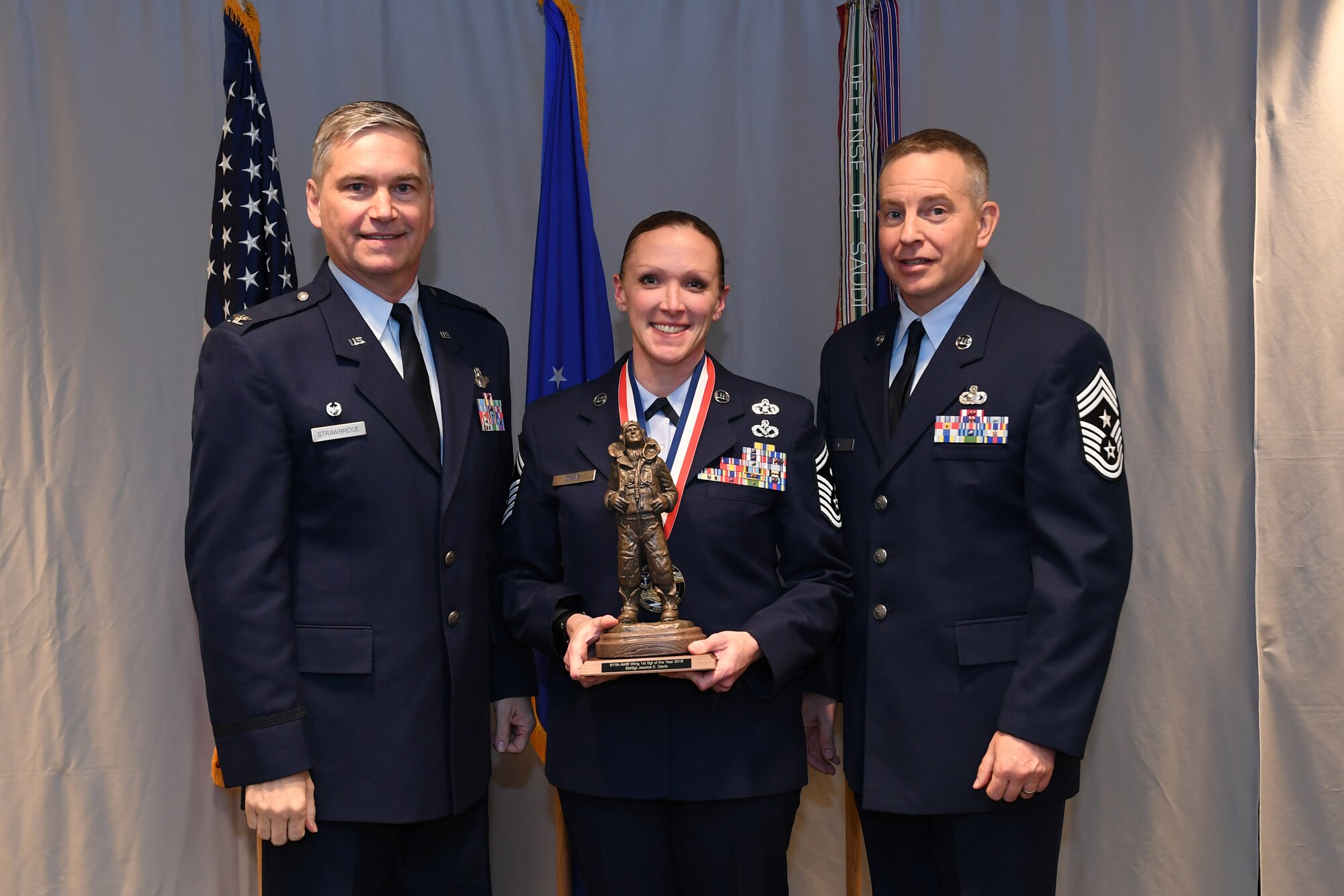 Senior Master Sgt. Jessica Davis, installation emergency manager with the 32nd Aerial Port Squadron, is awarded 911th Airlift Wing First Sergeant of the Year by Col. Douglas N. Strawbridge, commander of the 911th AW, and Chief Master Sgt. Christopher D. Neitzel, command chief of the 911th AW, during the 911th AW Annual Award Ceremony at the Pittsburgh International Airport Air Reserve Station, Pennsylvania, March 2, 2019. The 2018 awards ceremony recognized Airmen who went above and beyond in their service for the year 2018. (U.S. Air Force photo by Senior Airman Grace Thomson)