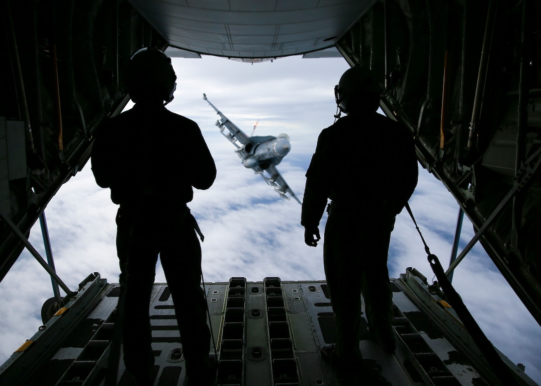 U.S. Marine corporals Reid Geyer and Michael Womack, crewmasters with Marine Aerial Refueler Transport Squadron 352, Marine Aircraft Group 11, 3rd Marine Aircraft Wing, prepare to refuel an F/A-18 Hornet with Marine Fighter Attack Squadron 323, MAG-11, carrying ten AIM-120 and two AIM-9X Air-to-Air missiles, over the W-291 training area in southern California, March 6.