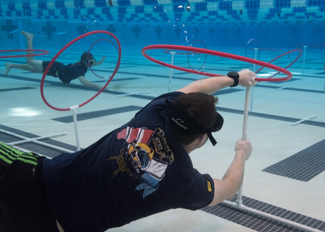 Naval Surface Warfare Center Panama City Division Mechanical Engineers Brian Toole (front) and Jacob Cornman help students untangle their remotely operated vehicles and reset the courses.