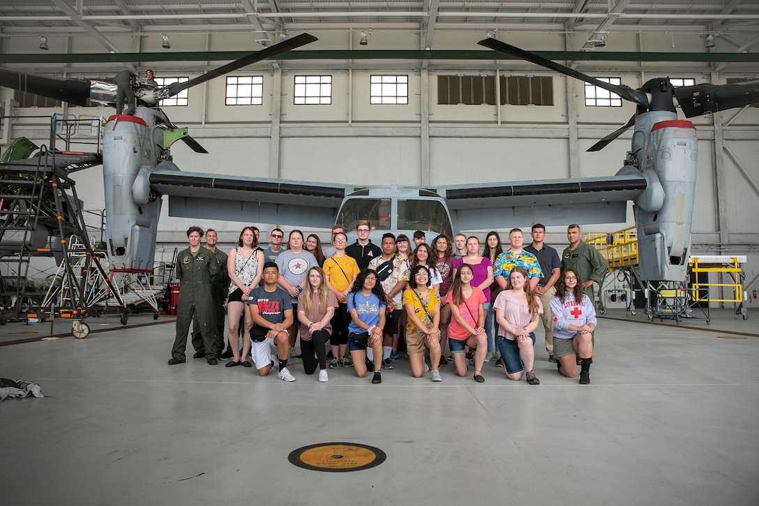 U.S. Marines with Marine Medium Tiltrotor Squadron 268 (VMM-268) and cadets from North Pole and Lathrop High School, Alaska junior reserve officer training camp (JROTC), pose for a group photo during a tour of the squadron, Marine Corps Base Hawaii, Mar. 11, 2019. The JROTC cadets were given a tour of VMM-268 to observe the MV-22B Osprey and learn about its capabilities. (U.S. Marine Corps photo by Sgt. Zachary Orr)