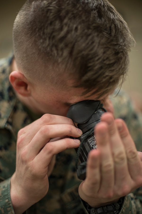 Lance Cpl. William Chelette, a field artillery radar operator with Headquarters Battery, 14th Marine Regiment, 4th Marine Division checks his night vision device at Fort Worth, Texas, Feb. 23, 2019. Marines with 14th Marines are part of exercise Dynamic Front 19, a multinational exercise in Latvia, which includes approximately 3,820 participants from 29 nations. (U.S. Marine Corps photo by Cpl. Niles Lee)